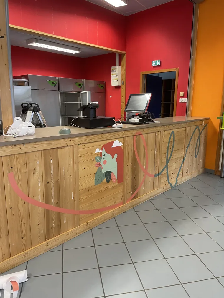 Habillage graphique coloré appliqué sur un comptoir en bois.