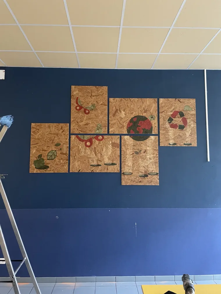 Composition de panneaux décoratifs en bois installée sur un mur bleu.