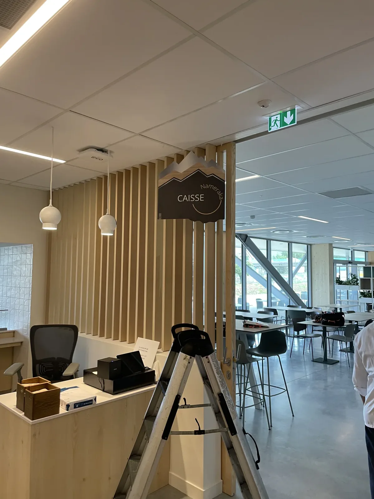 Panneau suspendu signalant la caisse dans un espace de restauration.