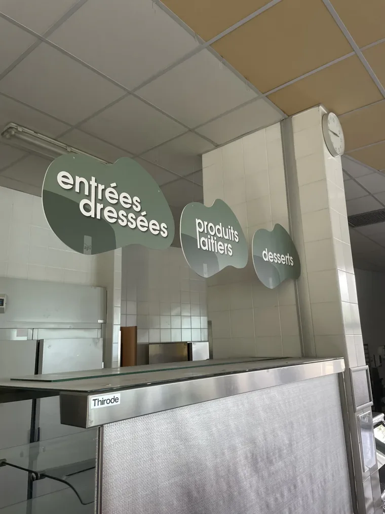 Signalétique suspendue indiquant les entrées, produits laitiers et desserts.